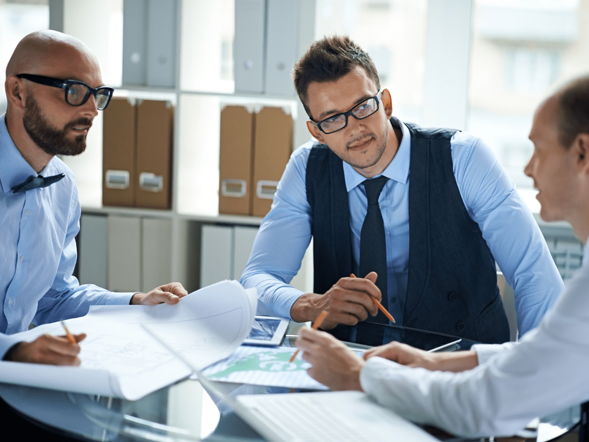 Three professionals discussing plans at meeting