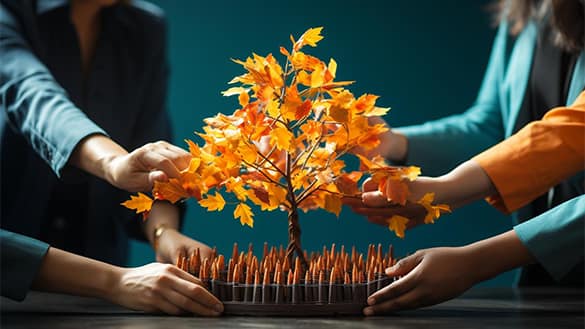 Hands nurturing a vibrant autumn tree.